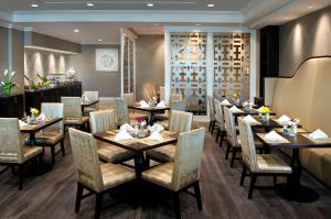 Hilton Greenville في غرينفيل: مطعم فيه طاولات وكراسي في الغرفة