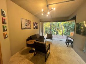Monkey Lodge - Casa na Mata في ريو دي جانيرو: غرفة معيشة مع أريكة وطاولة