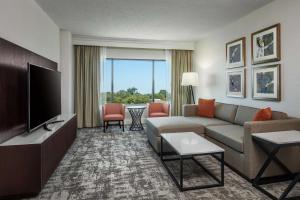a living room with a couch and a flat screen tv at Hilton Greenville in Greenville