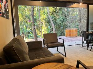 uma sala de estar com um sofá e uma grande janela em Monkey Lodge - Casa na Mata no Rio de Janeiro