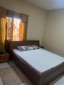 a bedroom with a bed and a window with curtains at Lassida 1060 in Ker Bakary