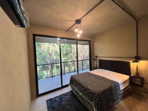 1 dormitorio con cama y ventana grande en Monkey Lodge - Casa na Mata en Río de Janeiro
