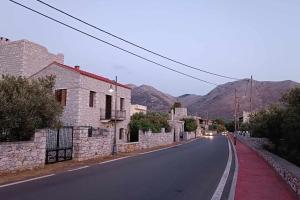 an empty street with buildings and mountains in the background at Sotula in Érimos
