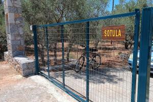 un portail bleu avec un panneau indiquant squula dans l'établissement Sotula, à Érimos