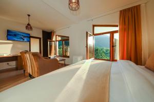 a bedroom with a large white bed with a window at Chalet Kujta in Peje