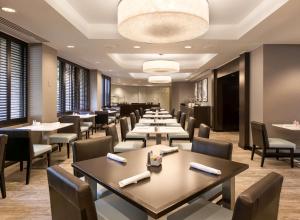 DoubleTree by Hilton Hotel & Suites Houston by the Galleria في هيوستن: صف من الطاولات والكراسي في المطعم