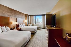 DoubleTree by Hilton Hotel & Suites Houston by the Galleria في هيوستن: غرفة فندقية بسريرين وتلفزيون بشاشة مسطحة