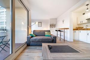 ein Wohnzimmer mit einem Sofa und einem Tisch in der Unterkunft Le petit Massena-cosy 2 pers balcon- Part Dieu in Lyon