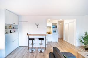 eine Küche und ein Wohnzimmer mit einer Theke und Stühlen in der Unterkunft Le petit Massena-cosy 2 pers balcon- Part Dieu in Lyon