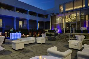 een patio met banken en tafels voor een gebouw bij The Kingsley Bloomfield Hills - a DoubleTree by Hilton in Bloomfield Hills
