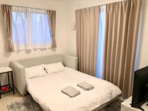 a bedroom with a bed with two towels on it at FL Residence The University of Tokyo II - Vacation STAY 12677 in Tokyo