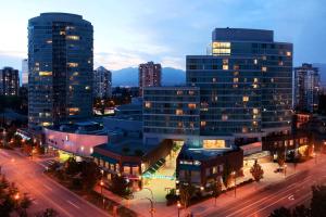 Una ciudad con edificios altos y una calle de noche. en Hilton Vancouver Metrotown, en Burnaby