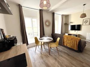 a living room with a couch and a table and chairs at L'Agate brune - Bourg-de-Péage in Bourg-de-Péage