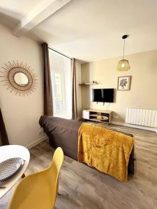 a living room with a couch and a table at L'Agate brune - Bourg-de-Péage in Bourg-de-Péage