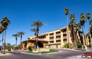 a building with palm trees in front of a street at Hilton Phoenix Resort at the Peak in Phoenix