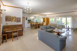 a living room with a couch and a piano at KORALIA MARATHON VILLA in Nea Makri