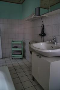 Baño blanco con lavabo y bañera en KomfortZuhause in Wermelskirchen, en Wermelskirchen