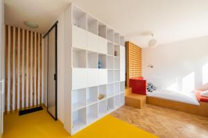 a bedroom with a bed and a room with a yellow floor at Spiska Standard Studio in Warsaw