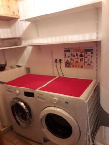eine Waschmaschine mit roten Matten darüber in der Unterkunft Charming apartment 12 pers, 3*, Aime-La-Plagne in Aime La Plagne