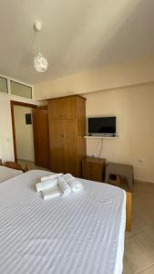 a bedroom with a white bed with towels on it at Overview Apartments Saranda in Sarandë