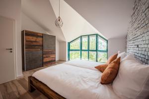 a bedroom with a large white bed with a window at Industrie Stil Apartment unweit vom See in Losheim