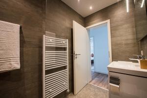 a bathroom with a sink and a mirror at Industrie Stil Apartment unweit vom See in Losheim +30 photos