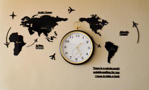 a clock on a wall with a map of the world at The Female Journey Hostel - JBR in Dubai