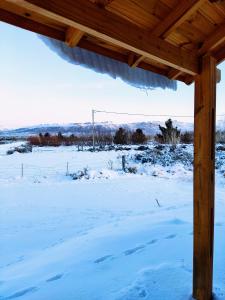 a view from a porch in the snow at Cabaña Maca Tobiano in El Calafate