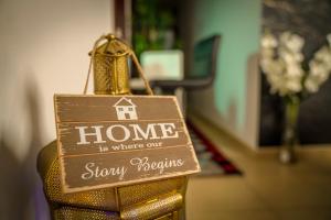a sign that says home is where our story begins at The Female Journey Hostel - JBR in Dubai