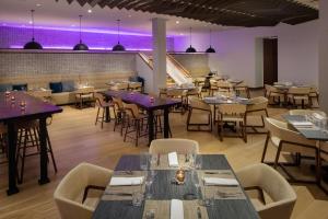 a restaurant with tables and chairs and purple lighting at The Bethesdan Hotel, Tapestry Collection by Hilton in Bethesda