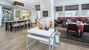 a dining room with a restaurant with tables and chairs at Hilton Garden Inn Albuquerque North/Rio Rancho in Rio Rancho