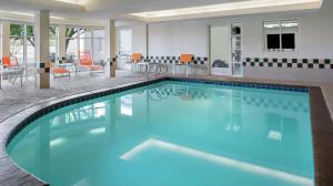 a large swimming pool with blue water in a hotel room at Hilton Garden Inn Albuquerque North/Rio Rancho in Rio Rancho