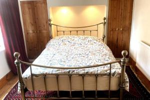 a bedroom with a metal bed with a comforter at Quirky City-Centre Cottage in Exeter