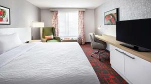 Habitación de hotel con cama y escritorio con TV. en Hilton Garden Inn Albuquerque North/Rio Rancho, en Rio Rancho