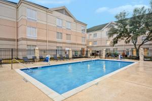 a swimming pool in front of a building at Hilton Garden Inn Austin Round Rock in Round Rock