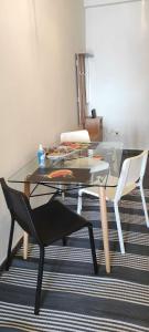 Sea side apartment في لوتراكي: طاولة زجاجية وكرسيين في الغرفة