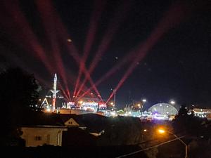 eine Stadt bei Nacht mit roten Lichtern am Himmel in der Unterkunft RM Festival Rooms Guca in Guča