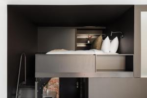 a bed in a black room with white pillows at Sonder RailSpur in Seattle