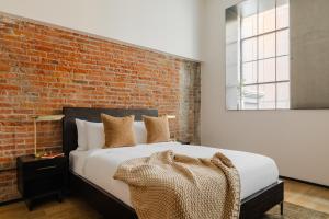 Un dormitorio con una pared de ladrillo y una cama en Sonder RailSpur, en Seattle