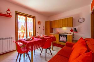 a kitchen with a table and red chairs in a room at Happy Guest Apartments - Mountain Panorama Borno in Borno