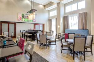 a dining room with tables and chairs and windows at Hampton Inn & Suites Westford-Chelmsford in Westford