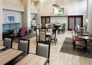 um restaurante com mesas e cadeiras e uma sala de jantar em Hampton Inn & Suites Westford-Chelmsford em Westford