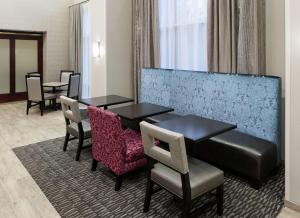 a hotel room with two tables and chairs at Hampton Inn & Suites Westford-Chelmsford in Westford