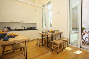 una cucina con tavoli e sedie in legno in una stanza di Nº 91 - Almirante Guest House a Porto