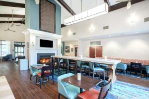 a lobby with a bar and chairs and a fireplace at Hampton Inn & Suites Nashville Franklin in Franklin