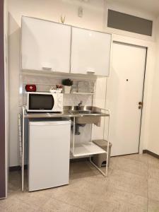 a small kitchen with a sink and a microwave at Republic B&B in Bitonto