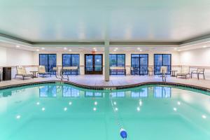 a pool in a hotel with tables and chairs at Hampton Inn Boston/Peabody in Peabody