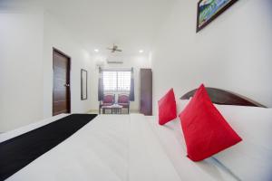 a bedroom with a large white bed with red pillows at Collection O Aar Bee Gee Hotel in Gummidipūndi