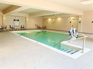 uma piscina num quarto de hotel com cadeiras e mesas em Hampton Inn Champaign/Urbana em Urbana