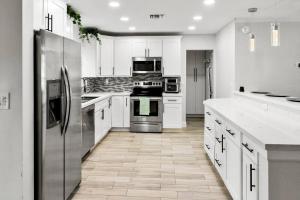 a kitchen with white cabinets and stainless steel appliances at Stadium Sunflower Miramar home, 3 bd, 2 ba in Miramar
